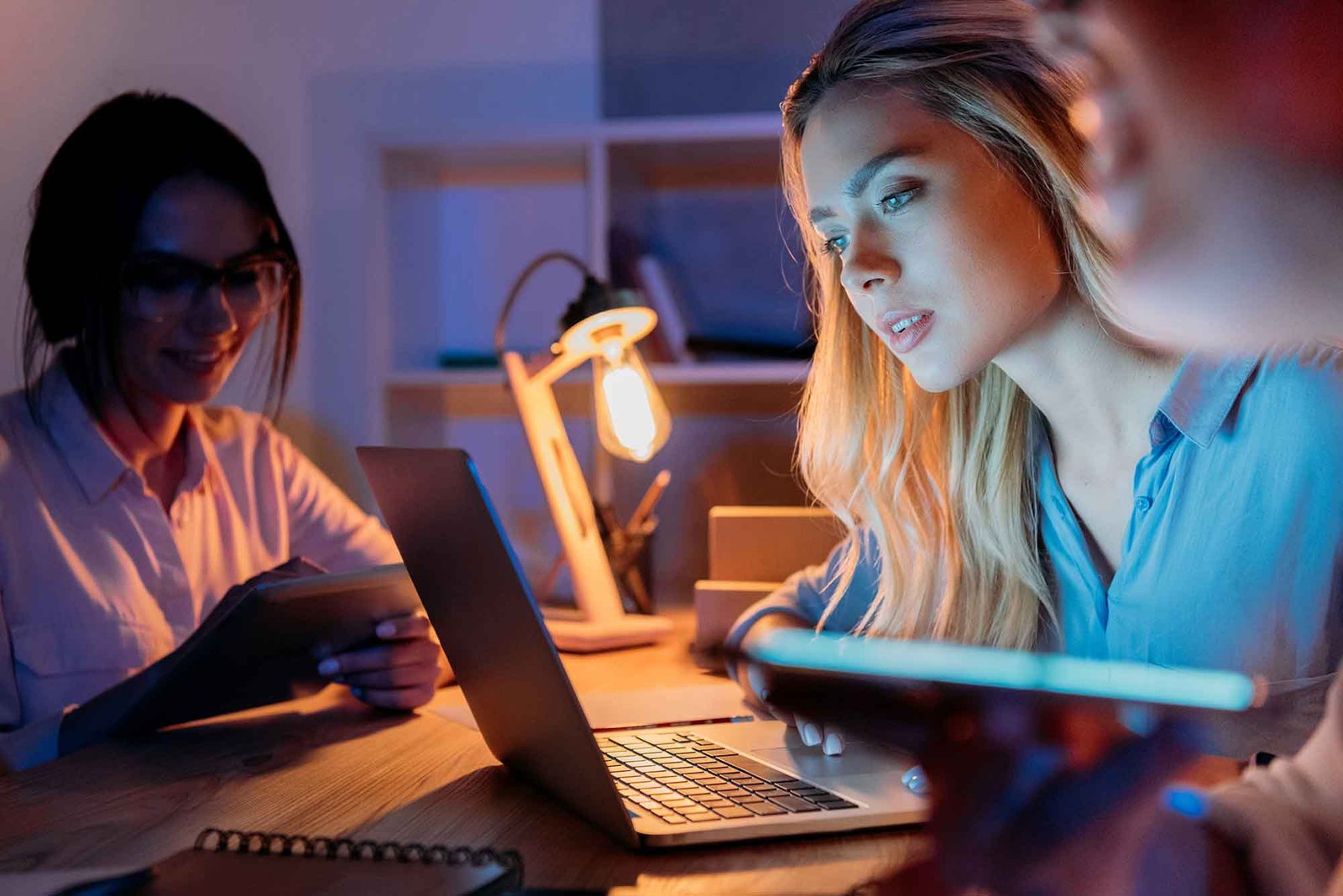 Jovens mulheres de negócios trabalhando em dispositivos digitais na experiência do usuário. Dino atua no treinamento de equipes, consultorias e mentorias.