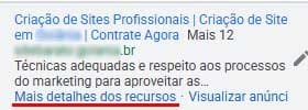Prévia de anúncio do Google Ads exibindo título, URL mascarada, descrição truncada e o link Mais detalhes dos recursos sublinhado em vermelho.